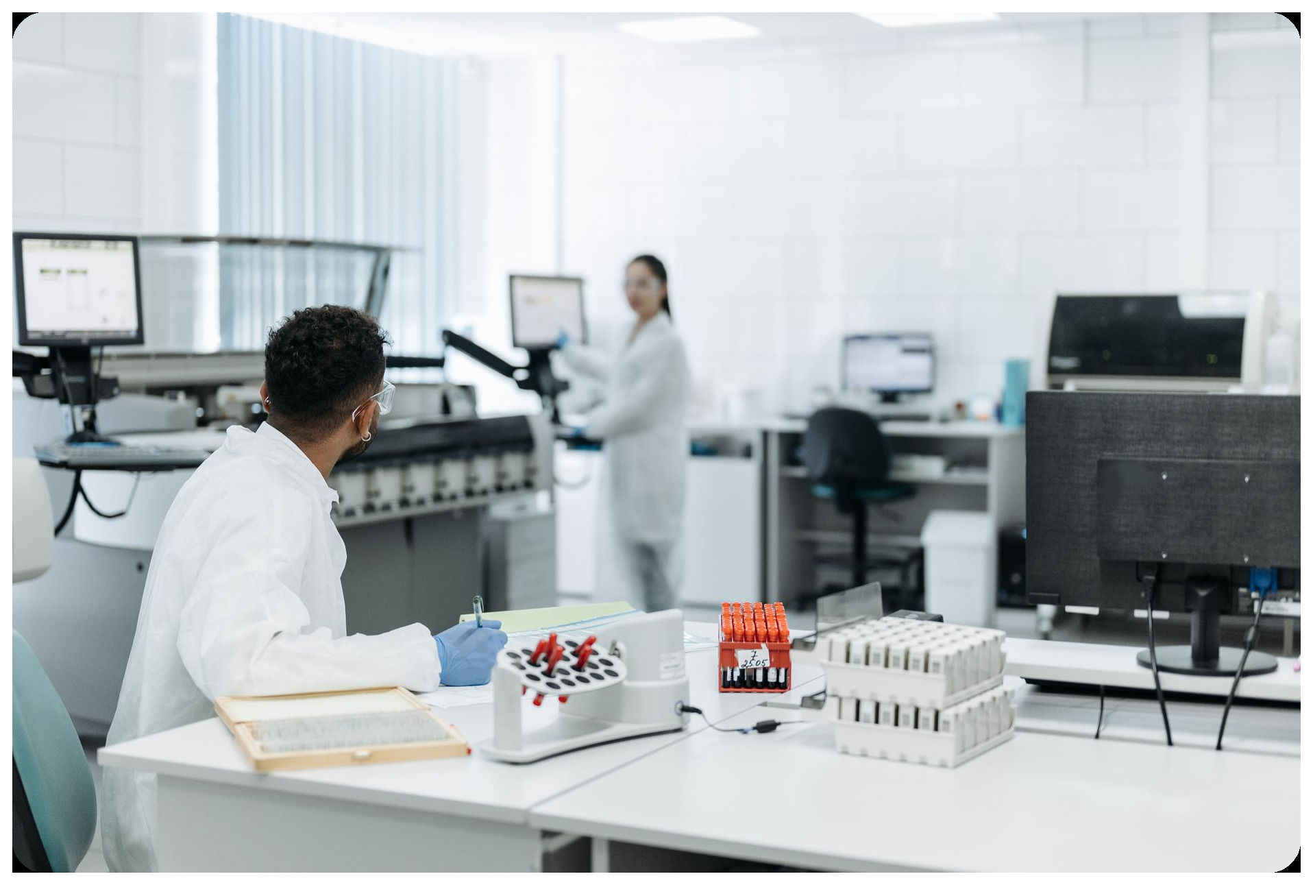 scientist in lab coat examining brain imaging data on monitor, microthrombi detection technology, research laboratory interior professional setting