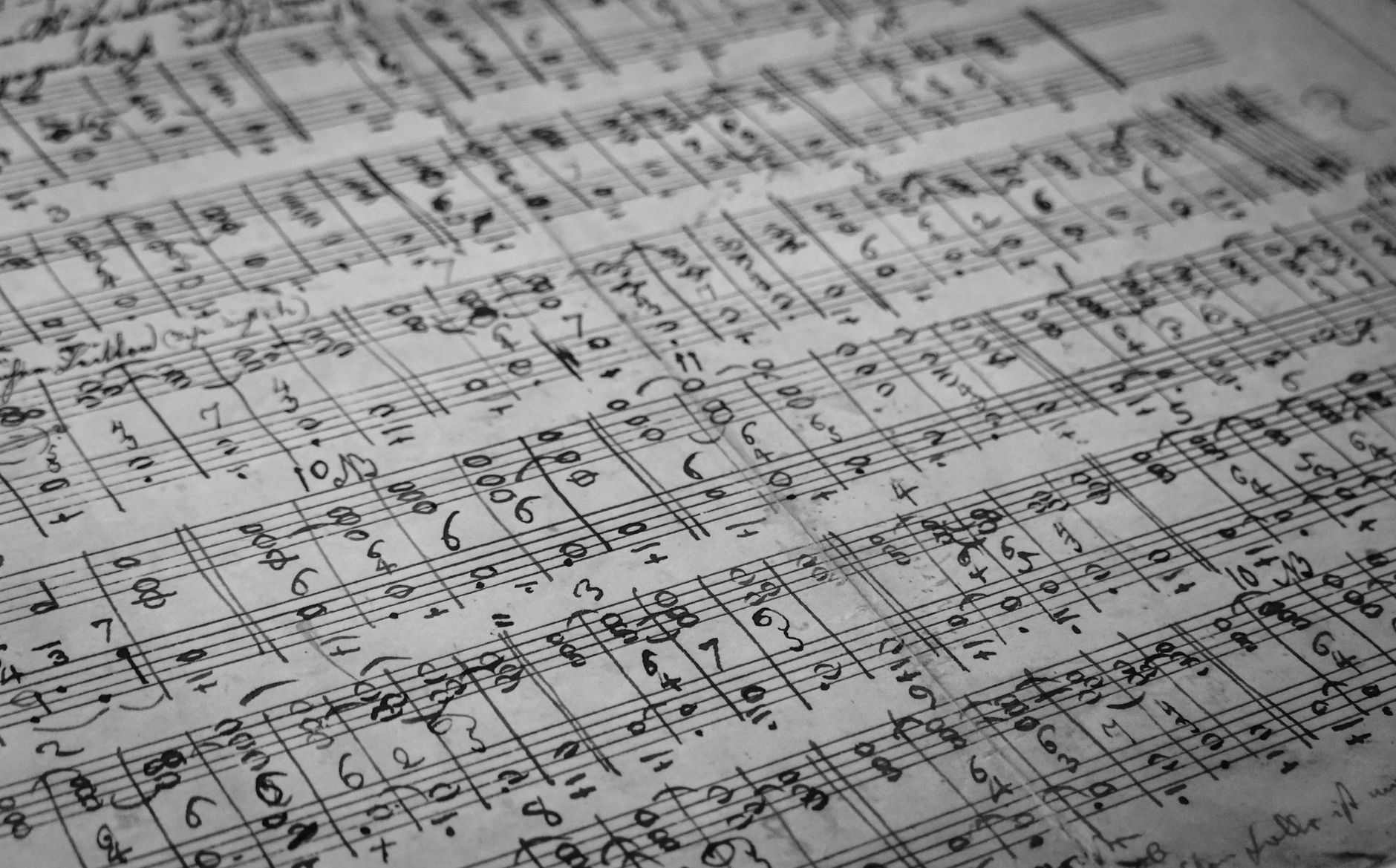 old handwritten sheet music manuscript and quill pen historic warm dramatic light
