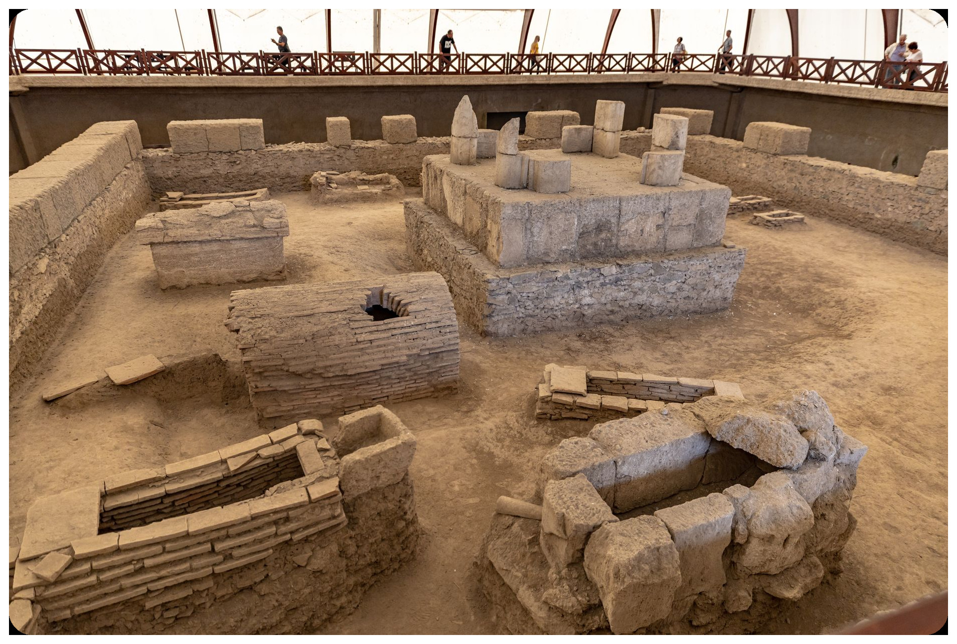 archaeological excavation of iberian stone house ruins at la illeta dels banyets alicante with mediterranean sea visible in background and students digging
