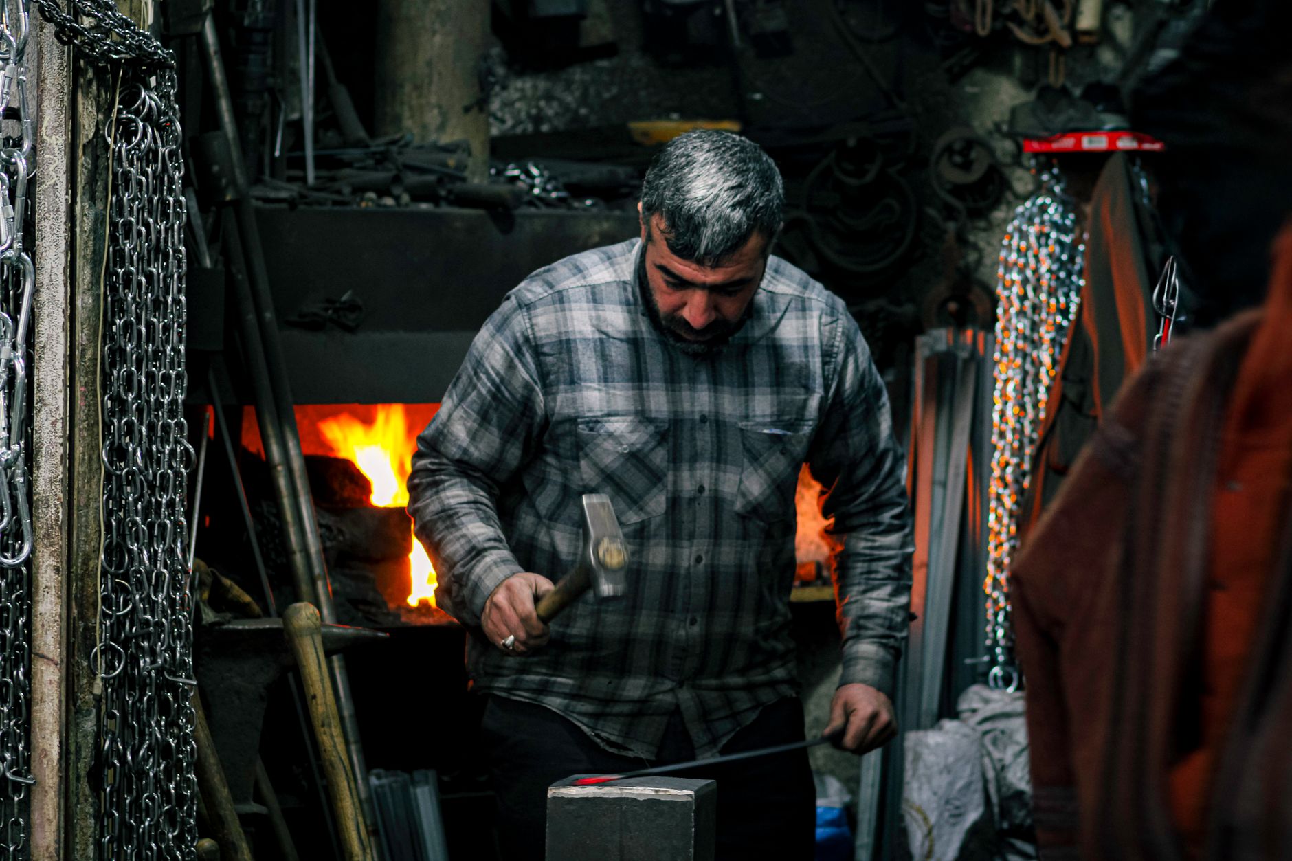 skilled ancient craftsman forging bronze chariot wheels by firelight metalwork precision ancient